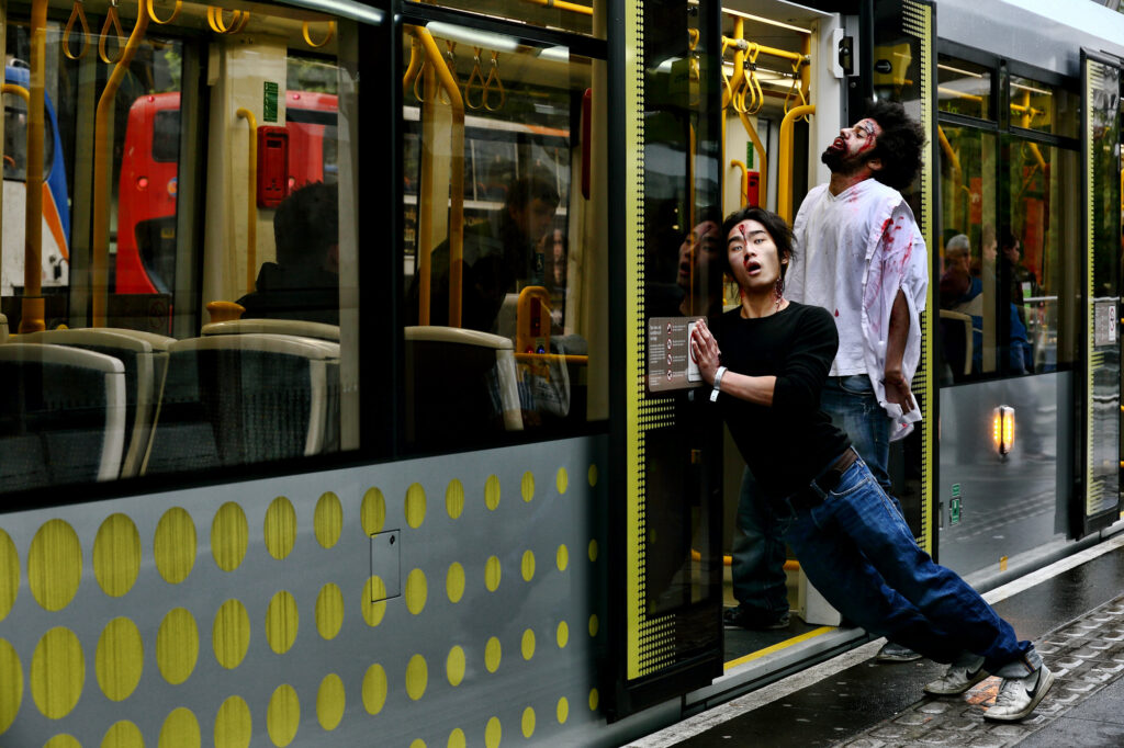 Unit stills photography on location in Manchester. Two zombies try and board a tram
