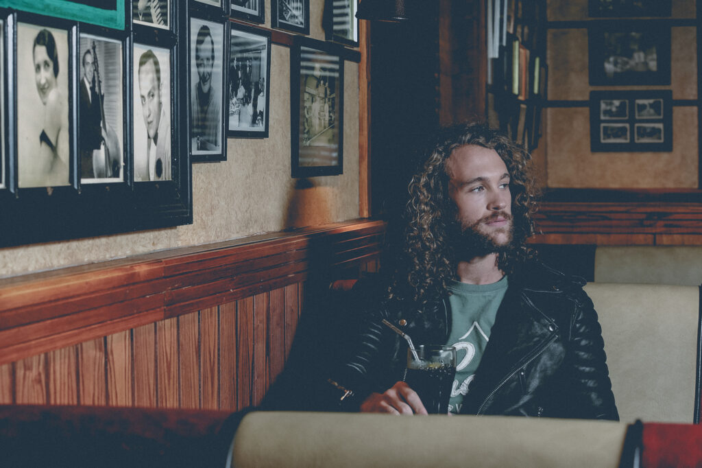 Unit stills photography on location in Manchester. Man sits in a booth while drinking