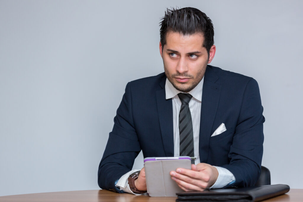 Unit stills photography on location in Manchester. A man sits at a desk on an iPad